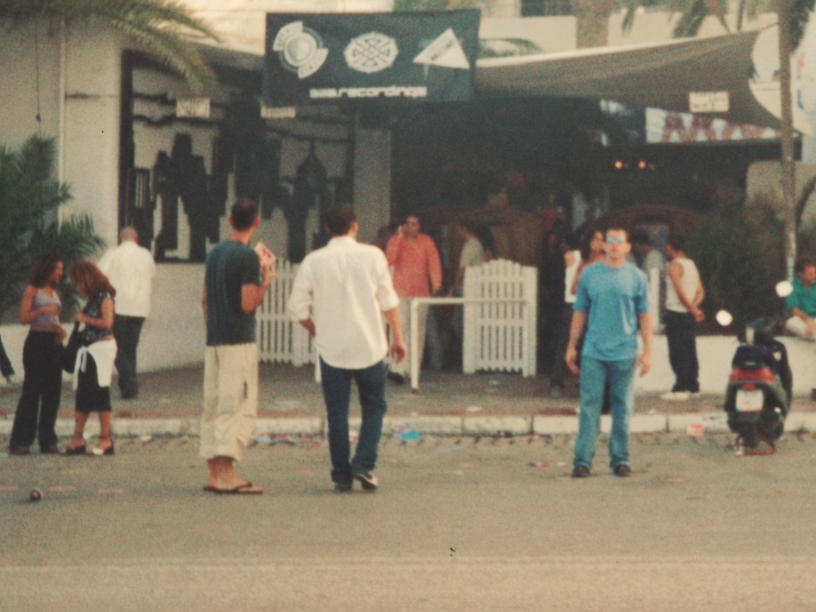 People outside a club on the island, daylight, around the turn of the century.