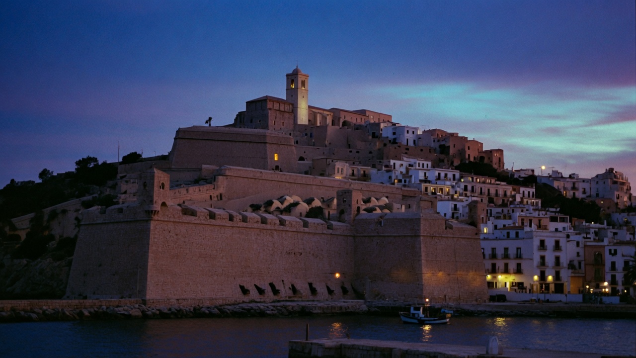 Dalt Vila, the fortified old town of Ibiza, at blue hour above the harbour.